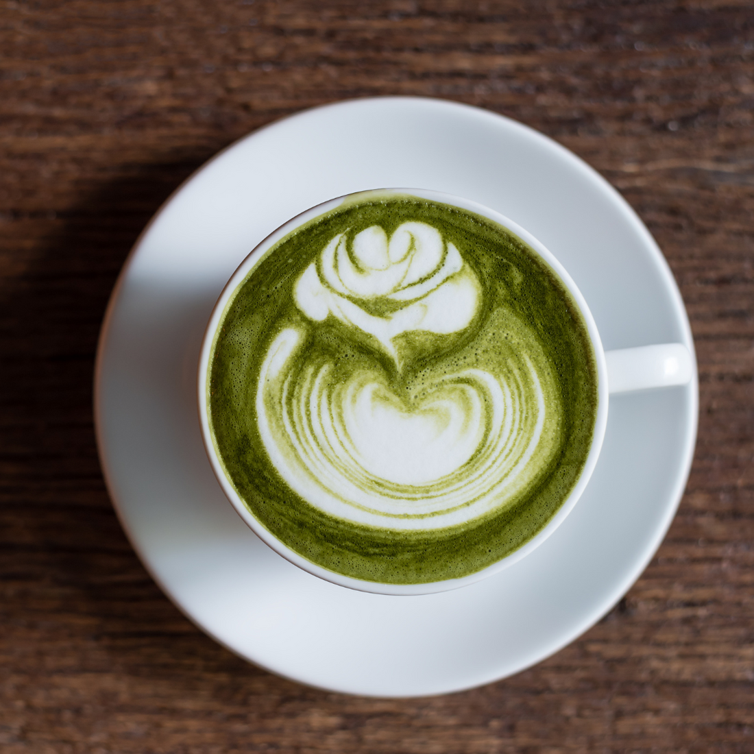 A matcha latte in a cup with foam art.