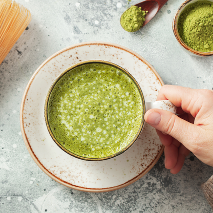 Single hand holding a cup of matcha green tea